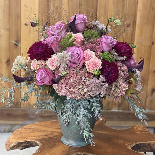 Lavender roses burgundy dahlias and pink hydrangea in a teal urn arranged by Durham luxury florist