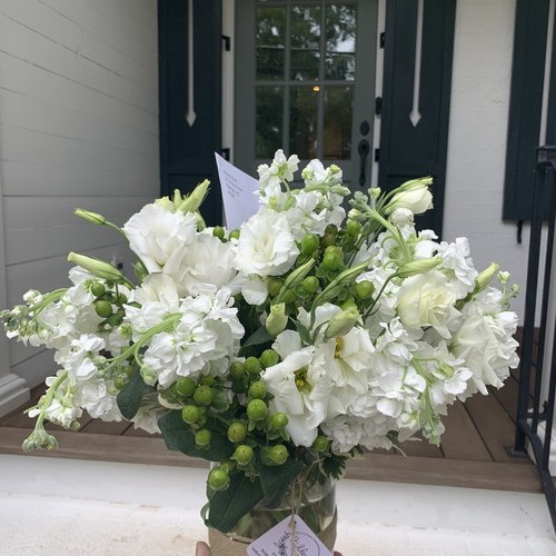 White lisianthus stock and green hypericum berries at a front door from luxury floral design Durham