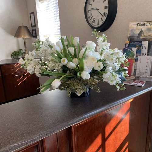 White tulips and stock on a reception desk arranged by a luxury florist Durham